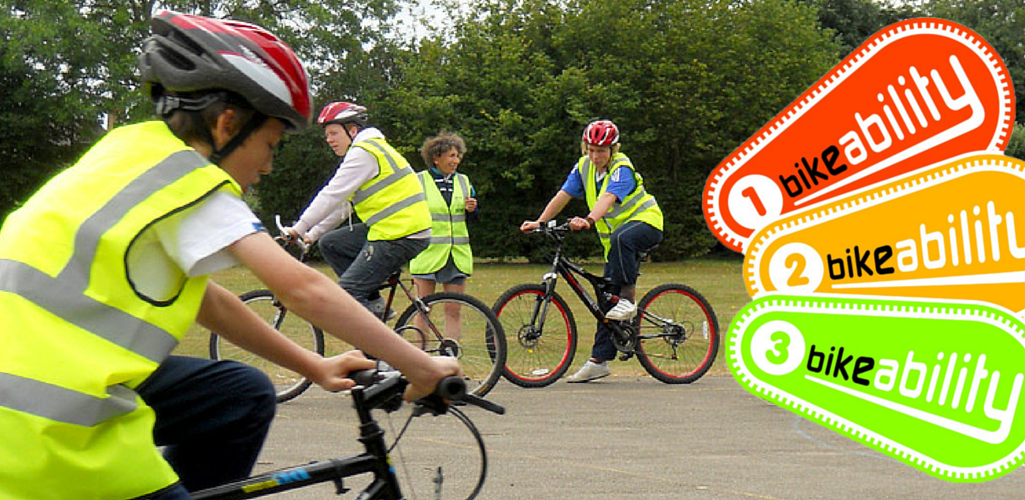 Instructor teaching pupils to ride a bike in a playground