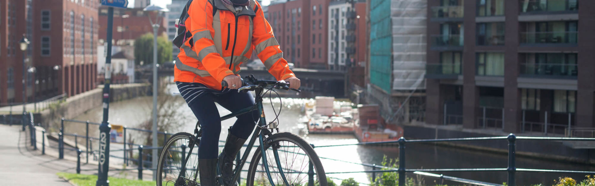 Women wearing hiviz cycling to work over a bridge