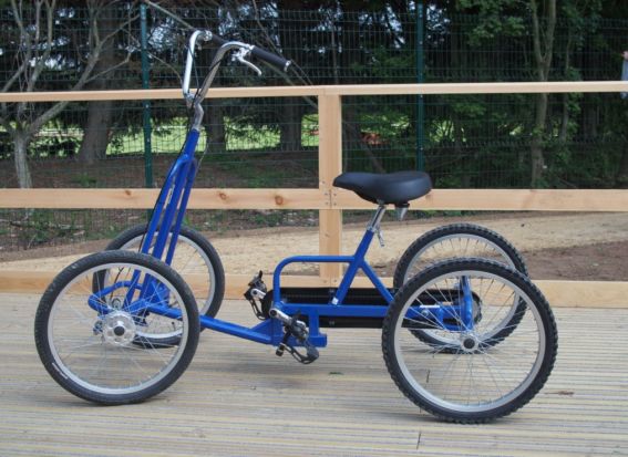 A blue adult size quadracycle on a wooden platform