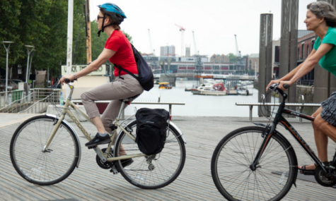 Two women cycling around bristol harbourside