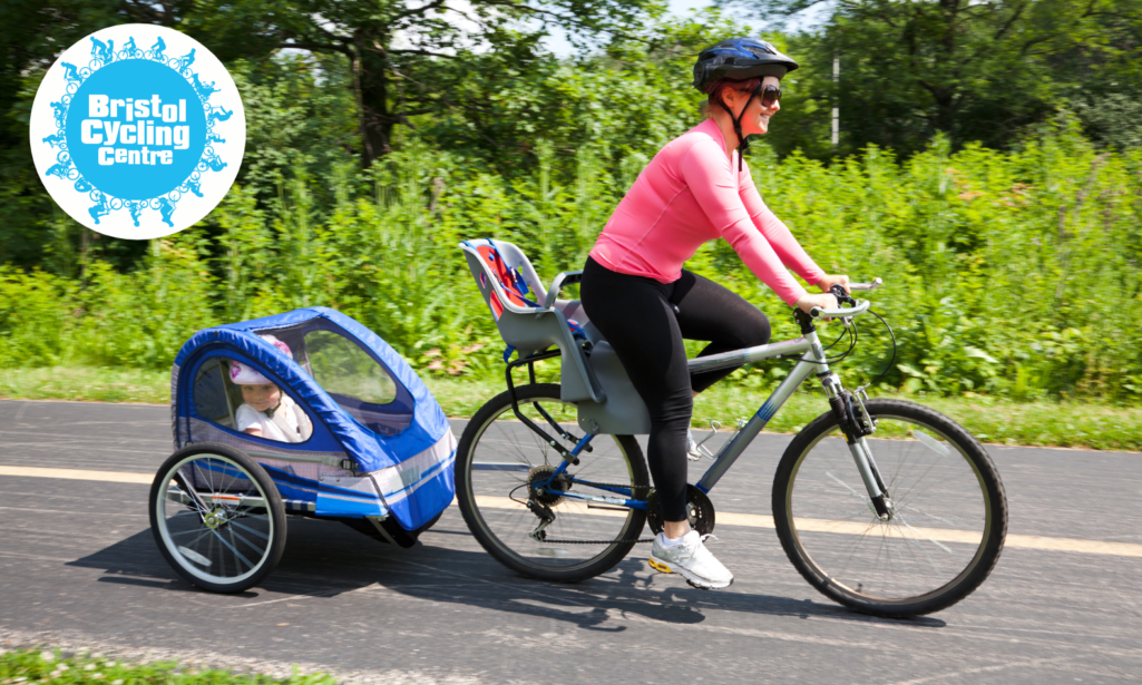 Photo of mother cycling with a child in a bike trailer